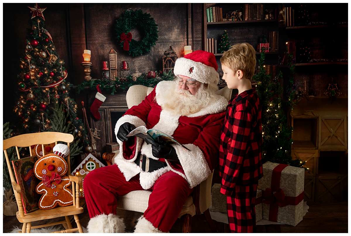 Santa reading with a little boy during his session.