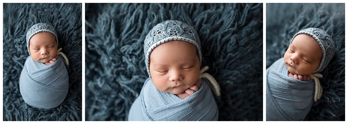 Baby boy wrapped in blue blanket wearing a blue bonnet.