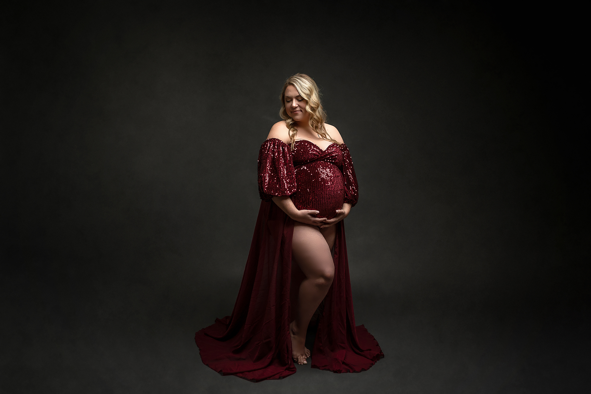 Pregnant mother wearing a maroon dress.
