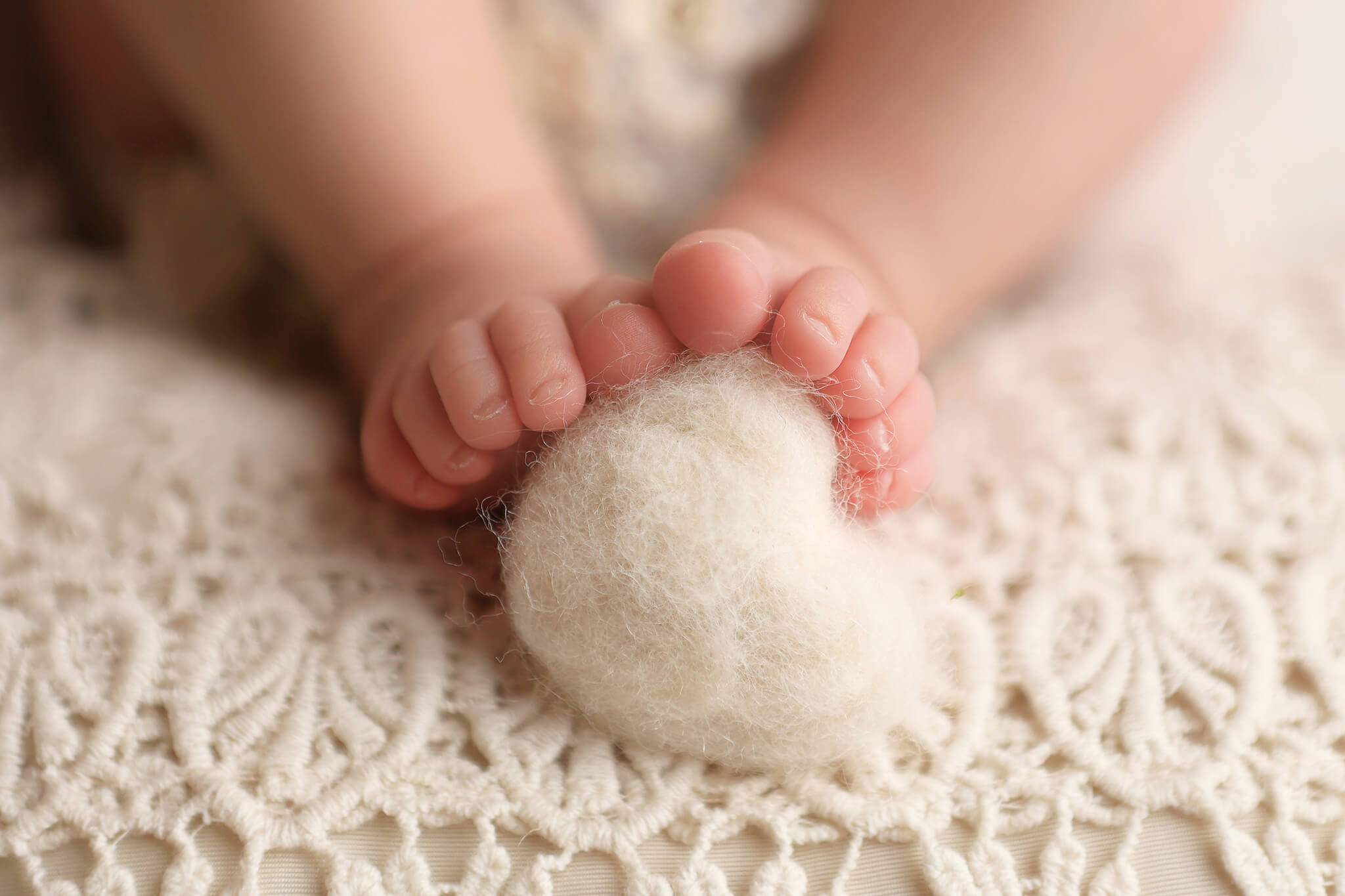 Newborn Toes hugging a felted heart.