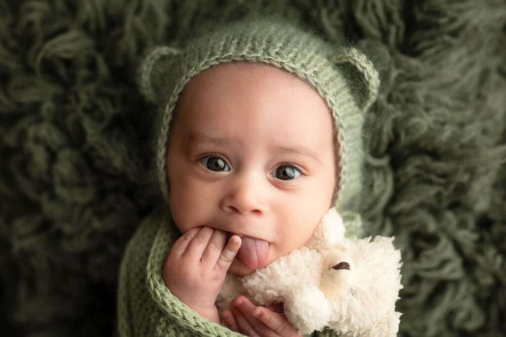 6 Week old baby boy snuggling a tiny bear during his session.