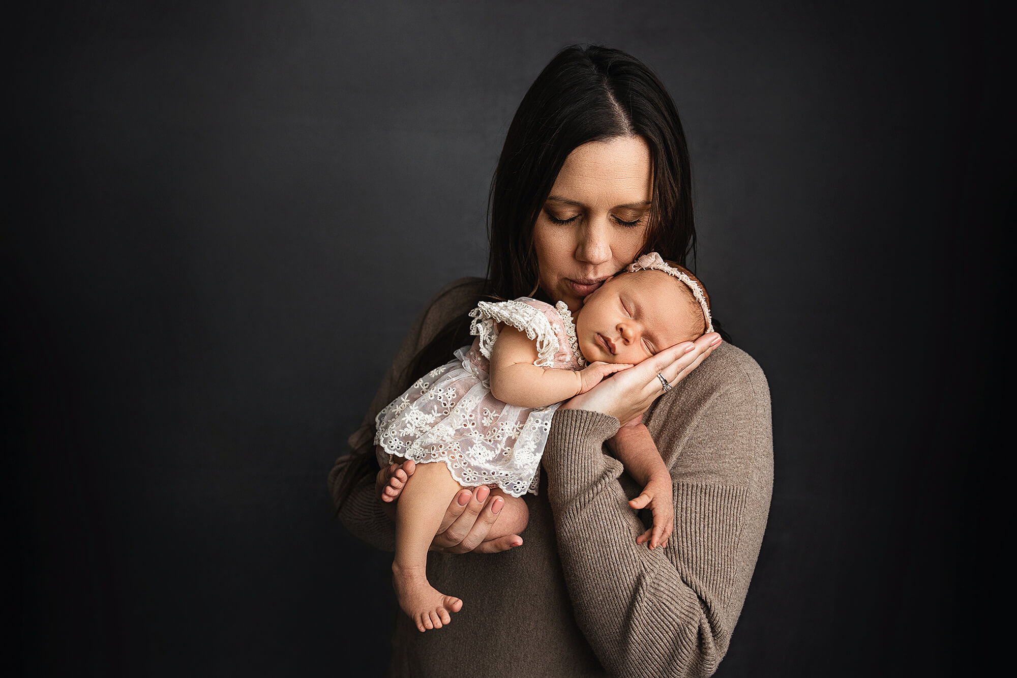 A new mother snuggles her baby girl for a sweet image captured by Jennifer Brandes Photography.