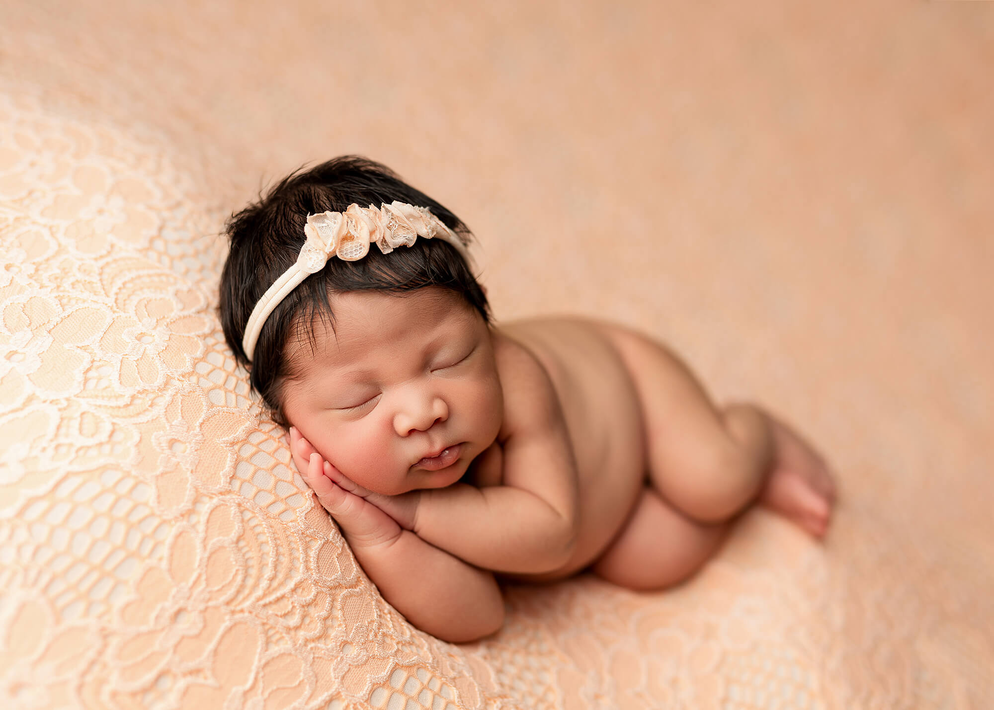 Side-lying pose newborn on a pink blanket - posed newborn photography in MN.