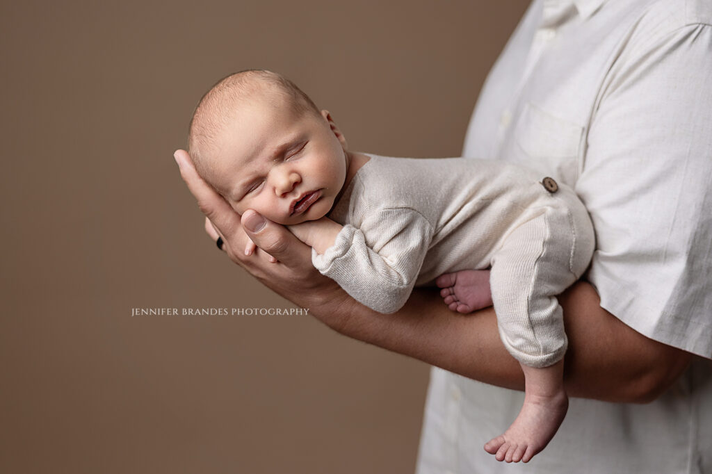 newborn photographer Greater Mankato Minnesota baby posed in dad's hands